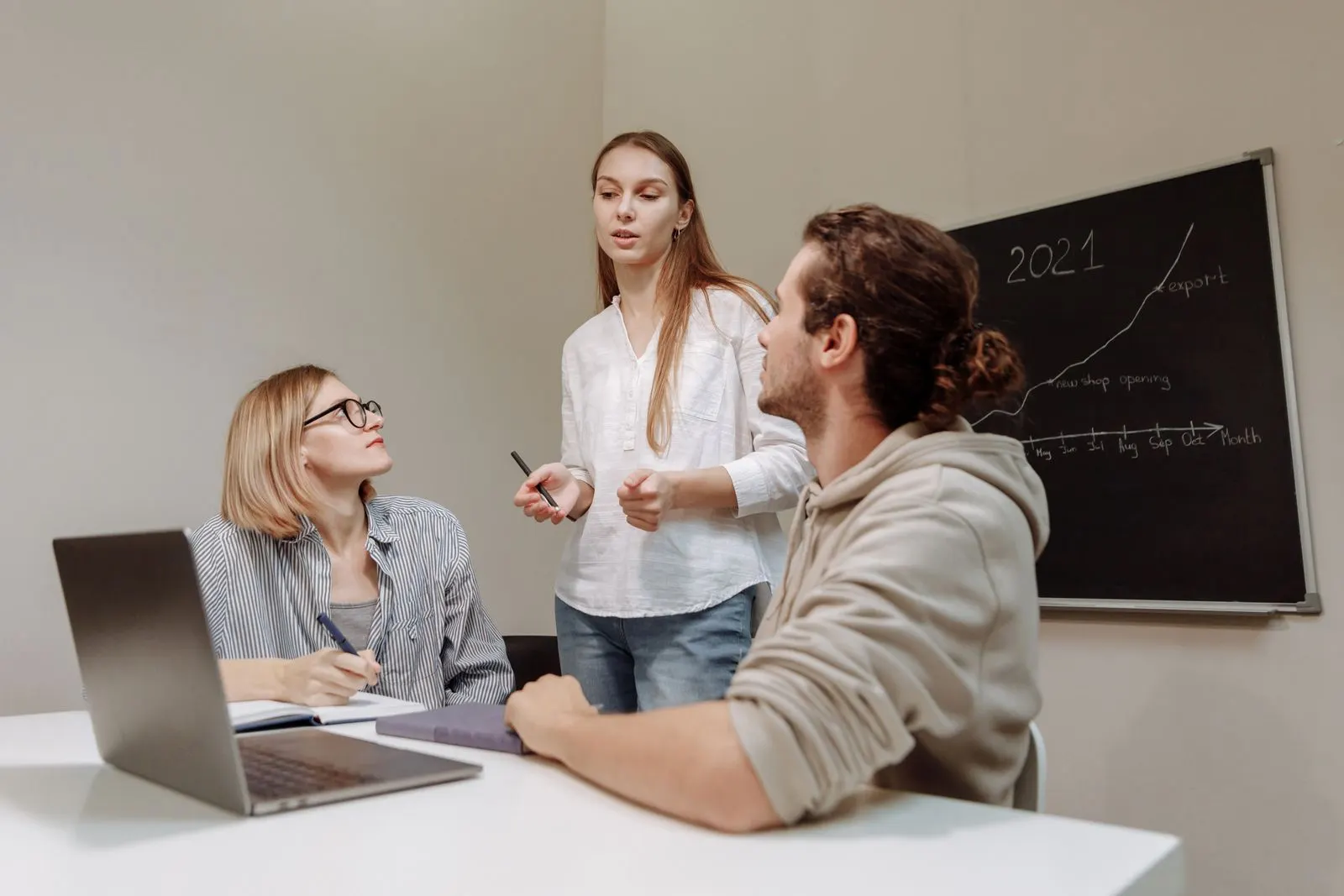 Small business team collaborating in a group discussion around a desk in a modern office